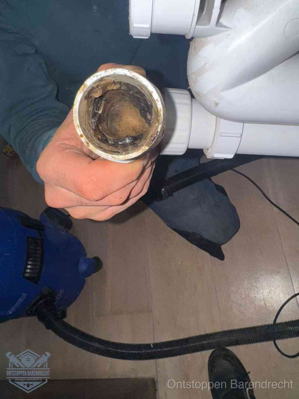 Een losgekoppeld afvoerbuisstuk dat van binnen volledig is dichtgeslibd, het gevolg van een verstopping te lang laten zitten in Barendrecht