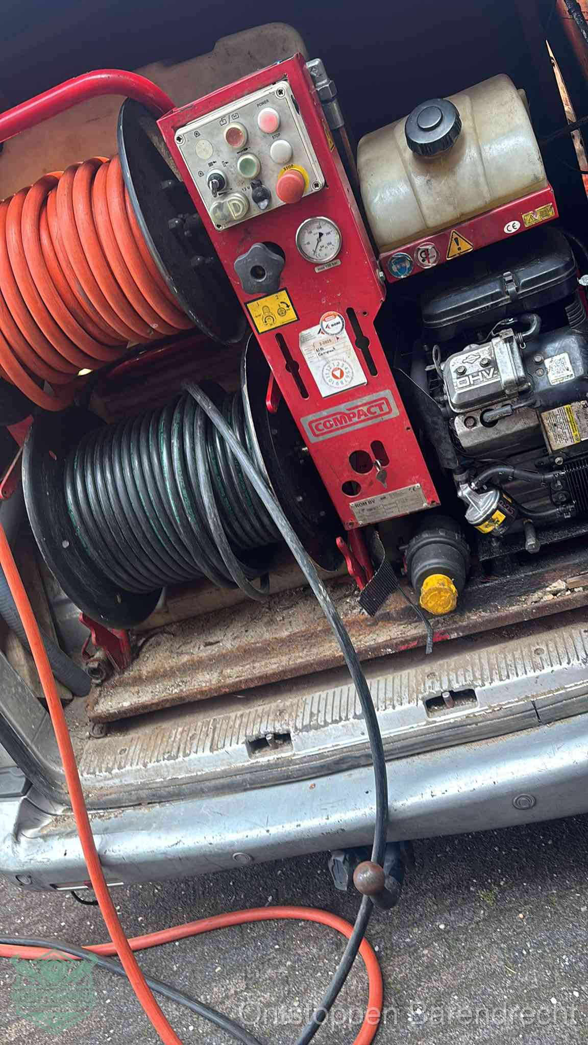 Een rood hogedruk-rioolreinigingstoestel in de laadbak van de bedrijfsbus, apparatuur voor een hardnekkige afvoerverstopping in Barendrecht