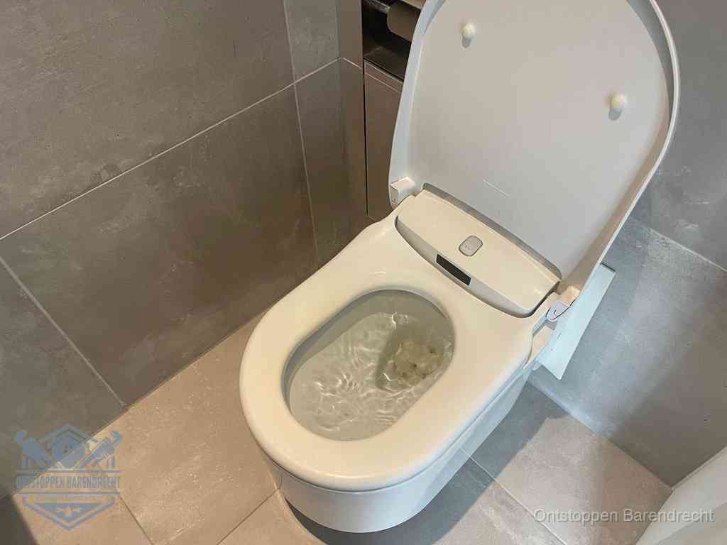 Een toiletpot vol troebel water met drijvend papier en restanten, de meest voorkomende oorzaak van een verstopte wc in Barendrecht