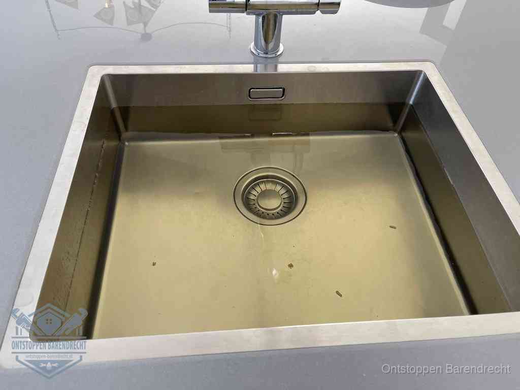 Stilstaand water in een rvs spoelbak dat niet wegloopt, een duidelijk signaal van een gootsteenverstopping in Barendrecht