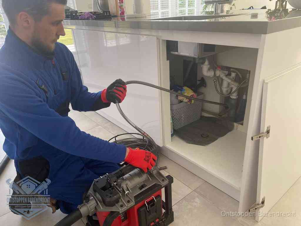 Een monteur reinigt de keukenafvoer grondig met een veermachine om terugkerende gootsteenverstoppingen te voorkomen in Barendrecht